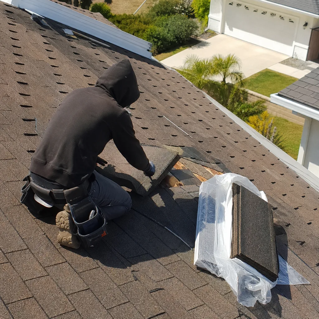 Professional roofer performing expert roof repair with asphalt shingles